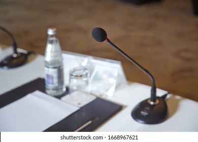Wired microphone set up on the front of conference room close up with blurred background. Wired microphone close up with copy space . Close up of microphone in concert hall or conference room .