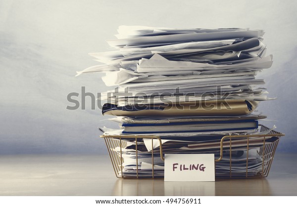 A wireframe filing tray, piled high with documents\
and folders, on a light wood veneer desk.  Drab hues for dreary,\
dystopian feel.