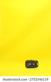 Wireless Bluetooth Camera Shutter Remote Control for iOS and Android on Minimalist Bright Yellow Background with Large Copy Space