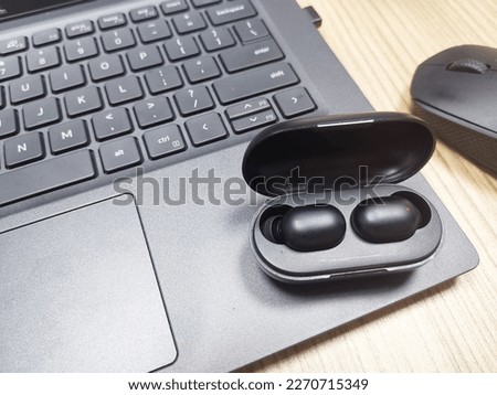 Wireless bluetooth earbuds with case isolated on laptop background technology