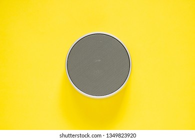 Wireless Bluetooth Speaker Portable On Yellow Background. Top View. Technology Concept. Minimal Style.