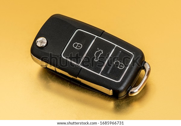 Wireless car key on the\
gold background.