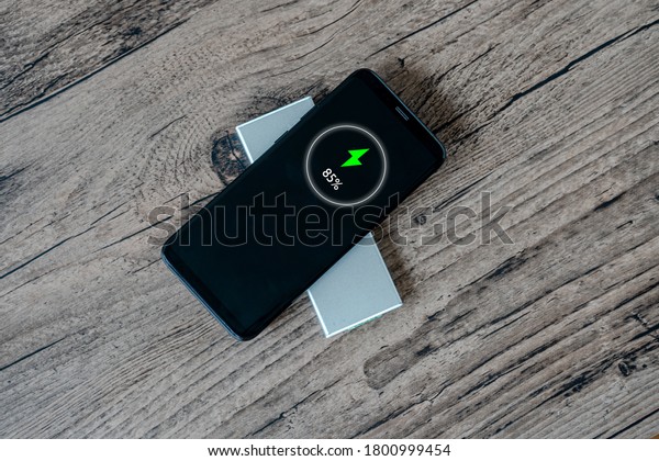Wireless charging of smartphone on restaurant table,\
concept 