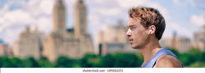 Wireless earbuds man walking running in Central Park New York city listening to music with wearable technology bluetooth earphone earpods panoramic banner.
