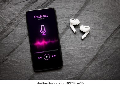 Wireless Earbuds And Mobile Phone With Podcast App On The Screen