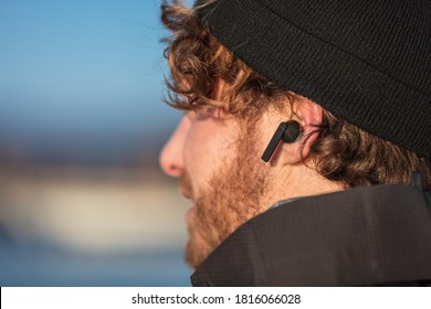 Wireless Earbuds Technology Device. Man Listening To Live Podcast While Walking Commuting To Work Early Morning In Cold Autumn. 