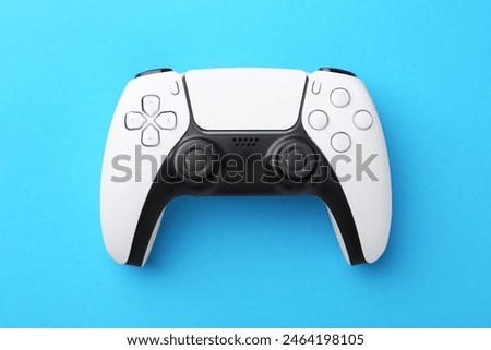 Wireless game controller on light blue background, top view