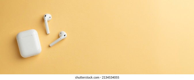 Wireless headphones and charging box, photographed leaving empty space on the right side of the photo - Shutterstock ID 2134534055