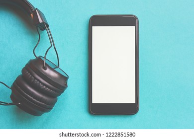 Wireless headphones and mockup smartphone on colorful background. Flat lay concept: headphones and telephone on blue pastel backgrounds.  - Shutterstock ID 1222851580
