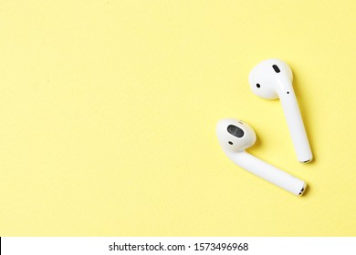 Wireless headphones on a yellow background with place for text. - Shutterstock ID 1573496968