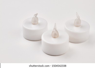 Wireless Led Candles With Remote Control. Three Electronic Flameless Tea Light Candles On White Background.