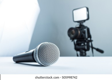 A wireless microphone lying on a white table against the background of the camera to led light.