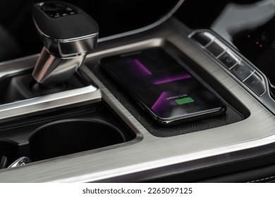 Wireless mobile charger in the modern car. Portable wireless car charger for smartphone.