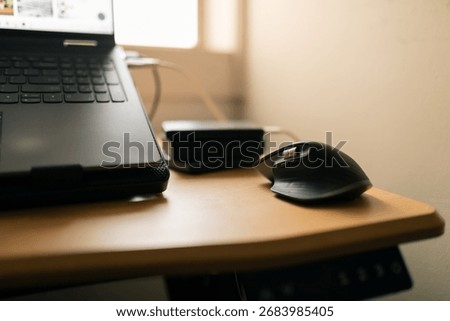 Wireless mouse on computer desk with stack of portable hard drives