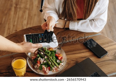 Wireless payment by using smartphone. Woman n the cafe restaurant.