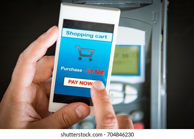 Wireless payment using smartphone and NFC technology. Close up hands. Customer paying with smart phone app in store. Cell phone shopping