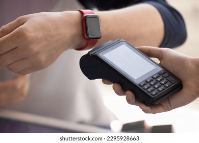 Wireless payment via smart watch using NFC tech, close up shot. Unrecognizable male buyer, customer making easy, quick, convenient e-pay for ordered services or purchased goods using modern wristwatch - Powered by Shutterstock