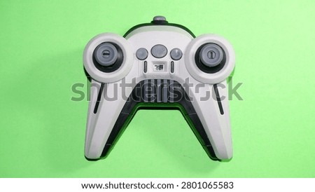 Wireless remote controller isolated on a green background. Modern electronic device featuring dual joysticks, suitable for drone operation, gaming technology, smart control, and innovation concepts.