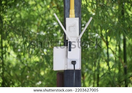 Wireless repeater WiFi extender on metal pole, Internet booster in green nature background