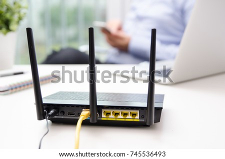 Wireless router and man using a smart phone in home or office. router wireless broadband home smart phone wifi technology concept