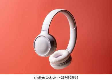 Wireless white headphones background on the pink close up. - Shutterstock ID 2194965965
