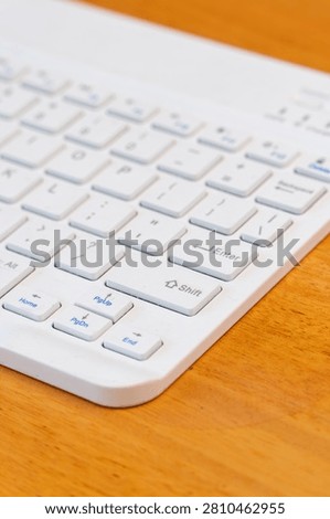 Wireless white keyboard with focus on shift key