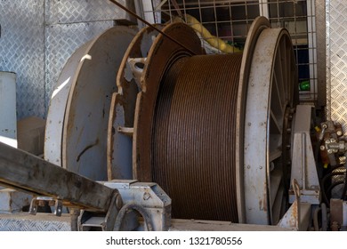 Wireline Equipment Hanging From Top Drive Ready To Be Lowered Downhole For Logging. An Oil Well Engineer Works From The Back Of Specialised Van To Log The Condition Of Steel Casing Inside An Oil Well