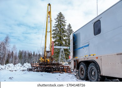 Wireline Equipment Hanging From Top Drive Ready To Be Lowered Downhole For Logging. An Oil Well Engineer Works From The Back Of Specialised Van To Log The Condition Of Steel Casing Inside An Oil Well.