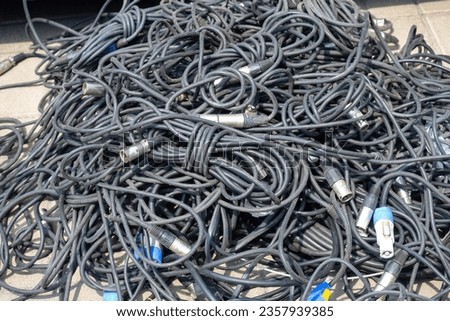 Wires from audio equipment. Tangled cables. Wires for concert equipment. Cable for lighting fixtures on ground. Tangled wires for electrical equipment. Cables for mounting concert stage