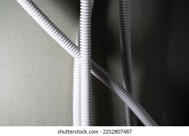 The wires in the protective corrugated pipe are held inside the plasterboard wall. Plastic insulation of wires against short circuit - Shutterstock ID 2252807487