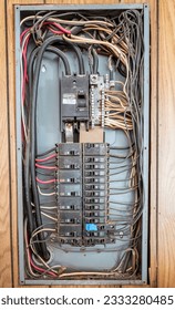 Wires running to and from an electrical panel with different sized circuit breakers and fuses plus missing, damaged and dirty parts.