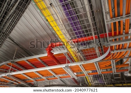 Wiring and cabling in large building. Pipes and cable trays. Building infrastructure and control systems