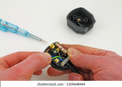  Wiring up a plug – A pair of hands wiring up a UK 3 pin plug
