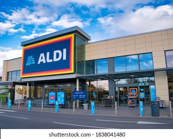 Wirral, UK - Oct 20 2020: The frontage and brand logo of a branch of German discount retailer Aldi, taken in a local retail park on Wirral, UK on a sunny afternoon