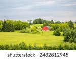 Wisconsin farmland in June with a red barn, horizontal