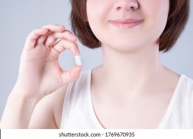 Wisdom Teeth Extraction, Happy Woman With Tooth In Hand On Gray Background, Dentistry Concept