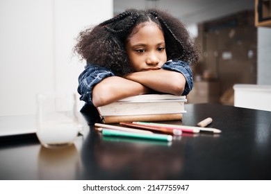 I Wish I Had A Study Buddy. Shot Of A Young Girl Looking Unhappy While Doing A School Assignment At Home.