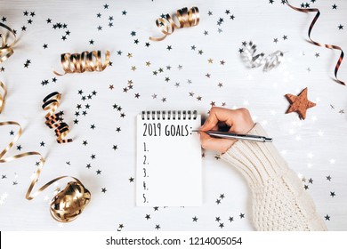 Wish lift for New Year. Holiday decorations and notebook with wish list on white rustic table, flat lay style. Planning concept.