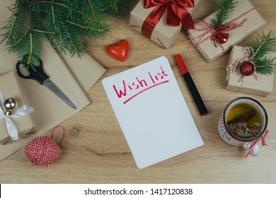 Wish List For New Year. Holiday Decorations And Notebook With Wish List On Wooden Rustic Table, Flat Lay Style. Planning Concept. 