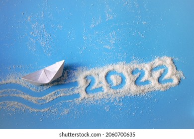 wish for the new year ship made of paper on a blue background with the numbers 2022, the concept of travel in the new year - Shutterstock ID 2060700635