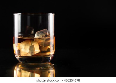 Wiskey In Glass With Ice On Black Background