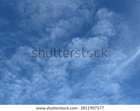 Wispy cirrus clouds form delicate, feathery patterns across a clear blue sky.