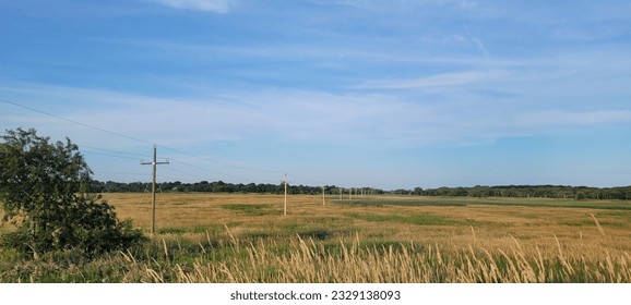 Wispy clouds in a blue sky over a field, Massachusetts - Powered by Shutterstock