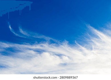 Wispy feathery cirrus clouds drift across a vibrant deep azure sky creating a serene atmosphere and a sense of boundless freedom in a bright sunny day outdoor environment