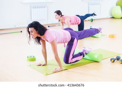 Wit women one leg extension kneeling kickbacks, exercise for lower back, hips and buttocks exercising at fitness club