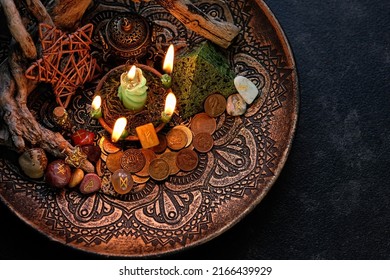 Witch altar with candles, old coins, stone runes, minerals, pentacle on dark table background. Magic for attracting money, wealth. witchcraft money esoteric ritual. occultism concept. top view