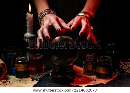Witch with crystal ball reading future on dark background