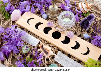 Witch Pagan Moon Phases Altar with crystals of selenite and amethyst, with candle and purple flowers