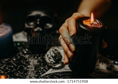 A witch performs a magic ritual with candles 
