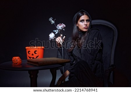 Witch sitting on her dark throne, casting spells, looking creepy and sinister, halloween, magic and skulls